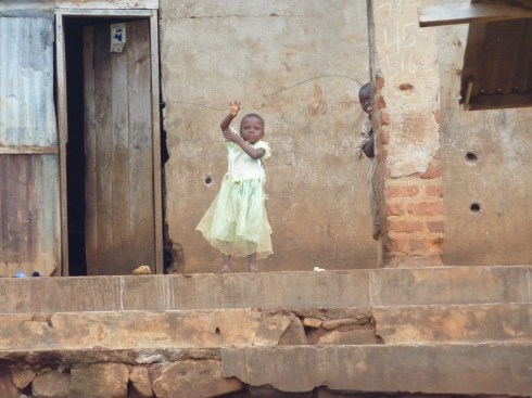 A girl waving at us (being muzungu) while we drive through Nyankunde but notice the bullet holes A girl waving at us (being muzungu) while we drive through Nyankunde, but notice the bullet holes